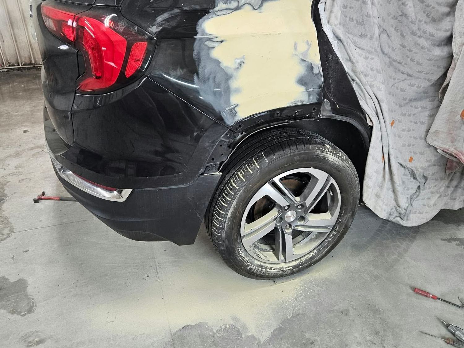 GMC Terrain rear quarter panel during repair, body filler visible